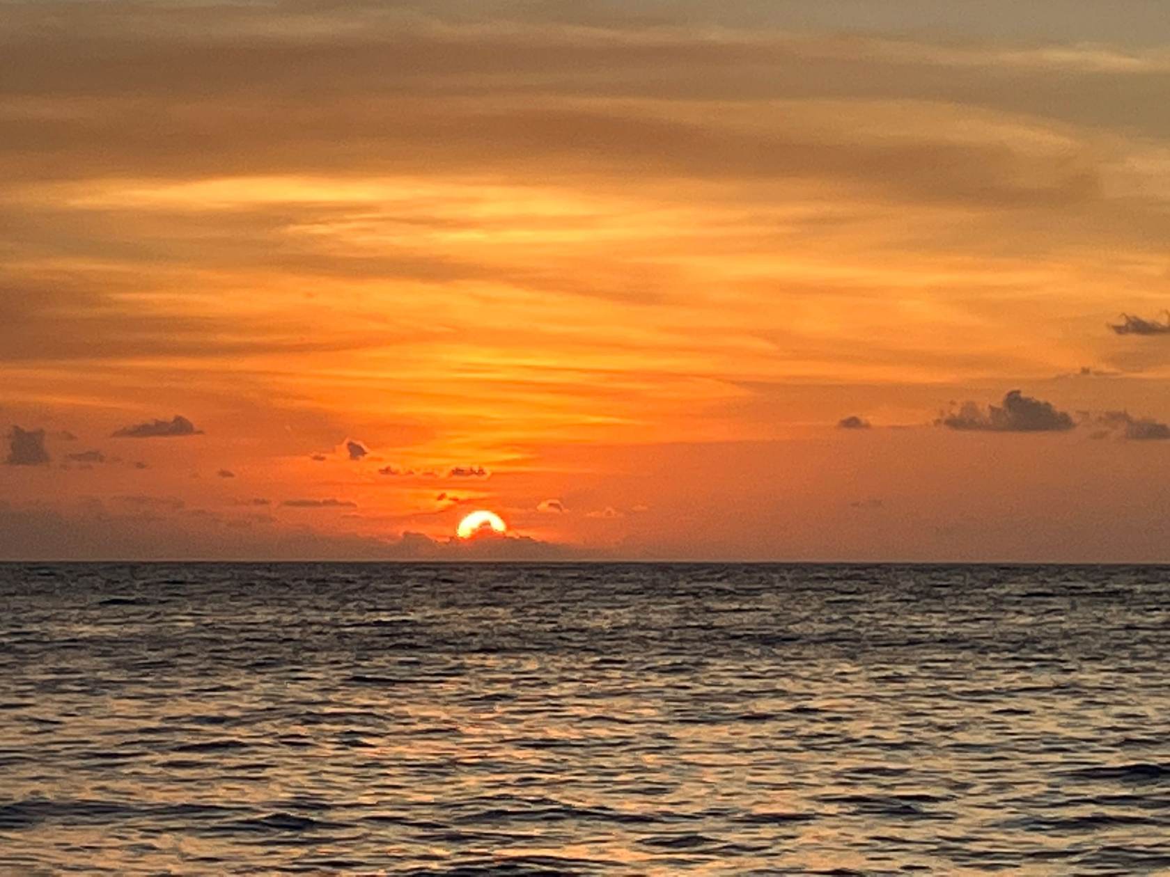 Spektakulärer Sonnenuntergang über dem Meer mit orangenem Himmel