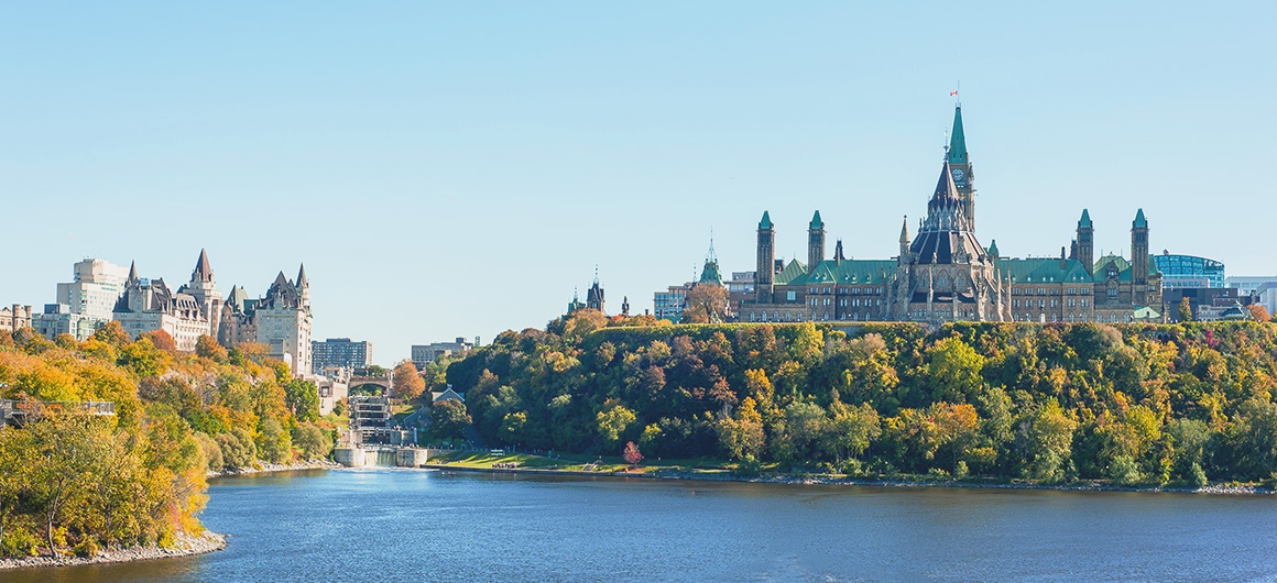 Parliament Hill & Ottawa River vom Wasser aus im Herbst mit bunt gefärbten Laubbäumen