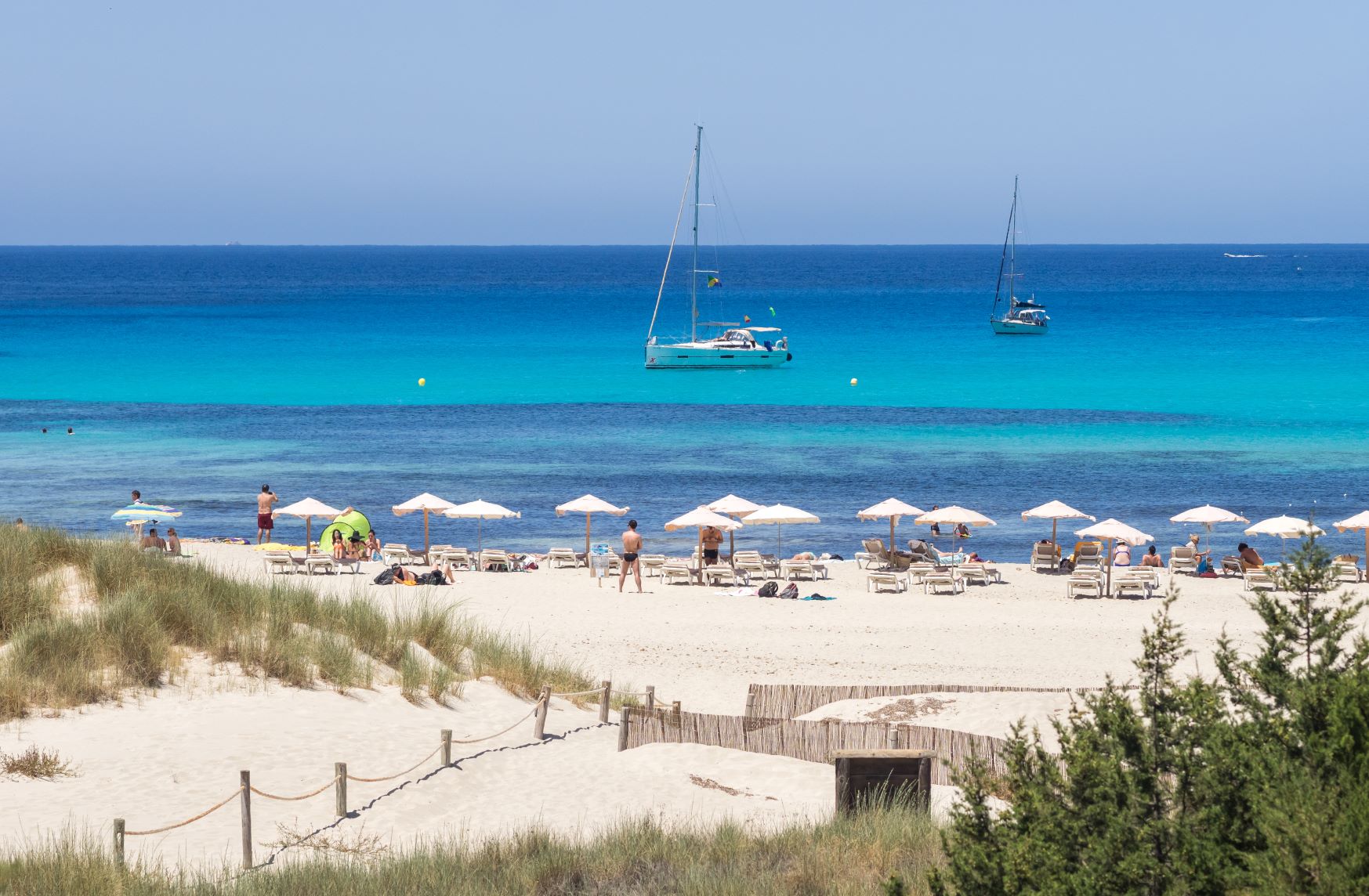 Segelyacht vor strahlend weißem Sand in der Cala Saona auf Formentera.