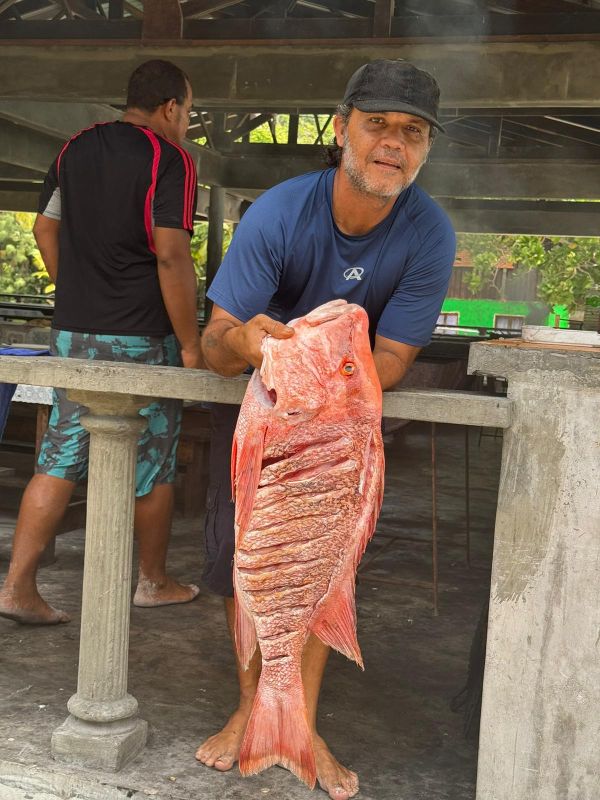 Einheimischer der Seychellen hält frisch gefangenen Fisch